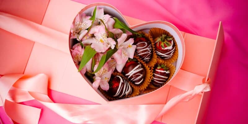 a heart shaped box filled with chocolate covered strawberries